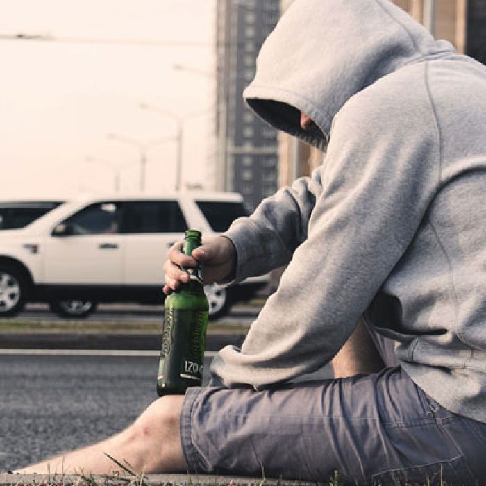 Drunk Driving Victims Jacksonville Florida | Man sitting on the side of the road holding a bottle